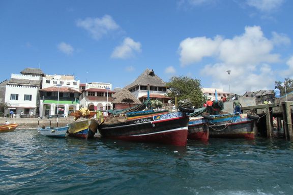 Bunte Holzboote und bunte Häuser am Anleger von Lamu town.